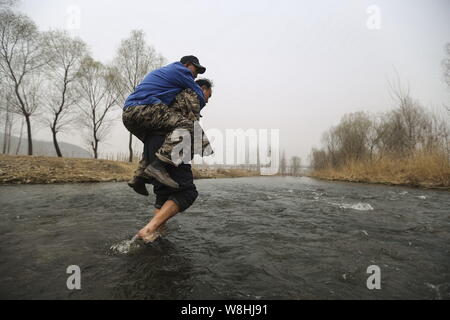 Armlose Chinese Jia Wenqi, unten, trägt seinen blinden Freund Jia Haixia auf der Rückseite, da Sie einen Fluss Bäume im Dorf Yeli zu pflanzen, Kreuz, Jingxing Stockfoto