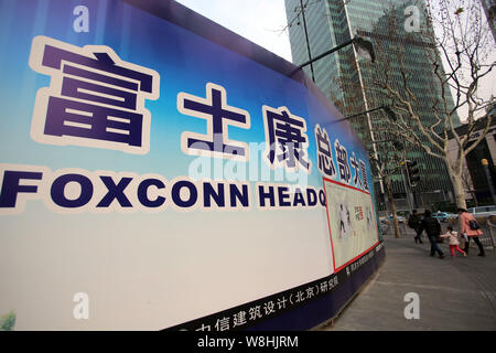 ---- Fußgänger vorbei an einem Namensschild des Foxconn zentrale Gebäude im Bau in Pudong, Shanghai, China, 6. Februar 2015. Foxco Stockfoto