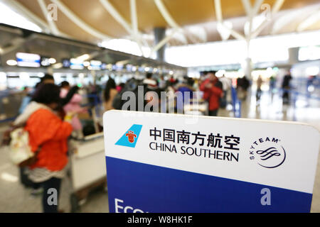 ---- Passagiere Schlange in Neben einem Namensschild von China Southern Airlines am internationalen Flughafen Shanghai Pudong in Shanghai, China zu prüfen. Stockfoto