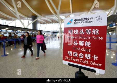 ---- Passagiere vorbei an einem Namensschild von China Southern Airlines am internationalen Flughafen Shanghai Pudong in Shanghai, China, 29. Januar 2015. Stockfoto