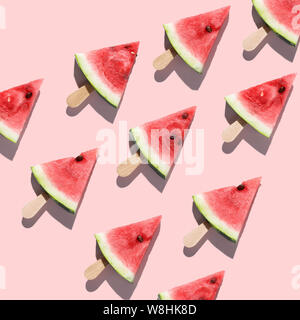 Aufgeschnittene Wassermelonen auf einem rosa Hintergrund angeordnet Stockfoto