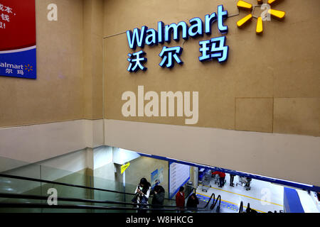 ------ Chinesische Kunden nehmen eine Rolltreppe in einem Supermarkt von Walmart in Shanghai, China, 16. Januar 2015. Der US-Einzelhändler Wal-Mart Stores Inc. Stockfoto