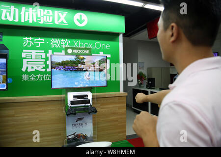---- Einen Kunden spielt elektronische Spiele auf einer Xbox eine Spielkonsole zu einem suning Haushaltsgeräte in Shanghai, China, 29. September 2014. Überwachungspersonen Stockfoto