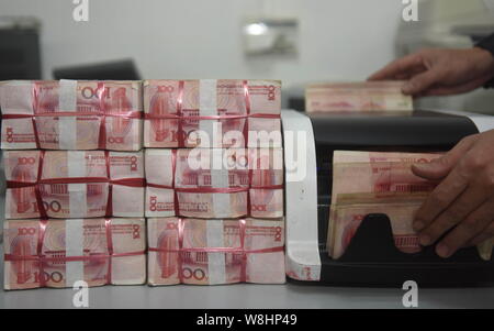 ---- Eine chinesische Angestellte verwendet eine Cash - Zählmaschine RMB (Renminbi) Yuan Banknoten bei einer Bank in der Stadt Qionghai zu zählen, der South China Hainan Provinz, Stockfoto
