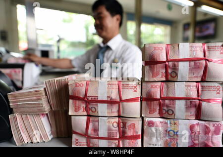 ---- Eine chinesische Angestellte verwendet eine Cash - Zählmaschine RMB (Renminbi) Yuan Banknoten bei einer Bank in der Stadt Qionghai zu zählen, der South China Hainan Provinz, Stockfoto