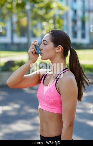 Junge Frau im Sport Top mit einem Inhalator. Stockfoto