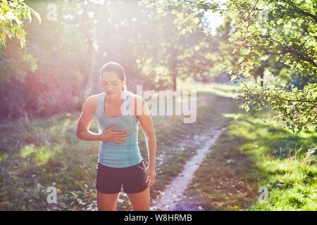 Junge Frau mit ruht Ihre Hand auf ihre Brust. Stockfoto