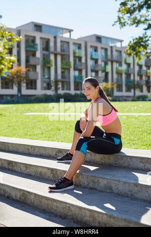 Junge Frau sitzt auf der Treppe, ausruhen. Stockfoto