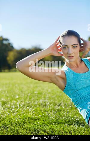 Junge Frau tun Crunch. Stockfoto