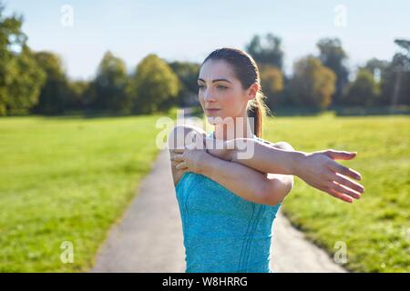 Junge Frau stretching arm. Stockfoto