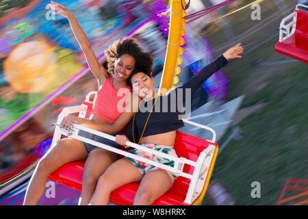 Zwei junge Frauen auf Messe Fahrt am Jahrmarkt. Stockfoto