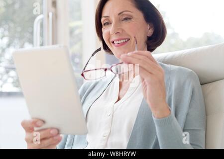 Reife Frau mit digitalen Tablet. Stockfoto
