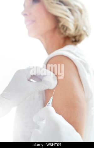 Reife Frau in Einspritzanlage in der Arztpraxis. Stockfoto