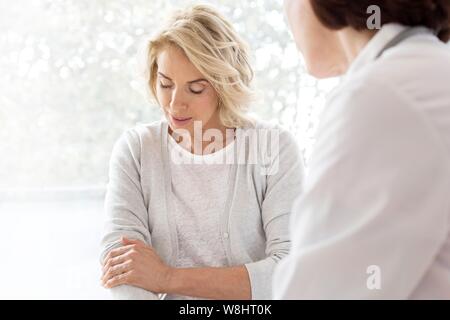 Reife Frau zeigt gp schmerzhafte arm. Stockfoto