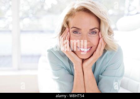 Reife Frau lächelnd und mit Blick auf die Kamera. Stockfoto