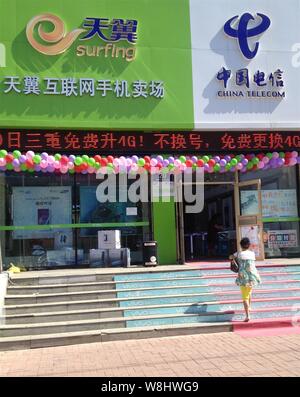 ---- Ein Kunde geht auf eine Filiale der China Telecom in Qiqihar City, im Nordosten der chinesischen Provinz Heilongjiang, 3. Juli 2015. China Telecom Sha Stockfoto