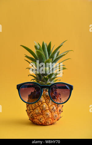 Mode hipster Ananas Obst mit Sonnenbrille auf gelbem Hintergrund Stockfoto