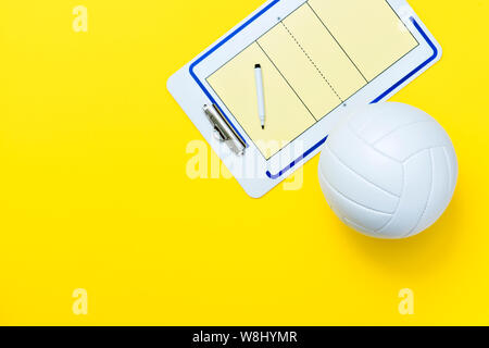 Volleyball und taktische Karte mit Markierung auf gelben Hintergrund. Ansicht von oben Stockfoto