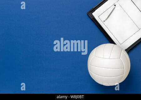 Volleyball und taktische Board mit Marker auf blauem Hintergrund. Ansicht von oben Stockfoto