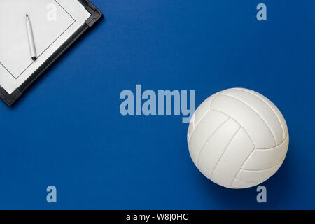 Volleyball und taktische Board mit Marker auf blauem Hintergrund. Ansicht von oben Stockfoto