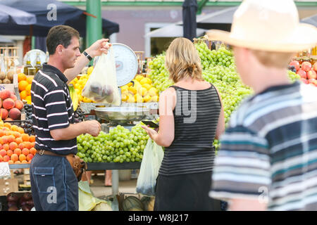 ROVINJ, KROATIEN - 26. Juli: Menschen auf einen Obstmarkt am 26. Juli 2009 in Rovinj, Kroatien. Eine Nahaufnahme von einem Verkäufer, der mit einem Gewicht von Pfirsiche für die Frau Stockfoto