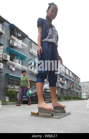 Ein 13-jähriges Mädchen mit dem Zunamen Xie steht barfuss auf den Blades von Fleisch Hackmesser in Wenzhou City, East China ¯ s Zhejiang Provinz, 22. Juni 2015. Ein 13. Stockfoto