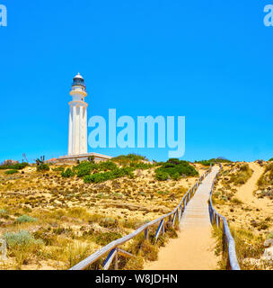 Holzsteg zum Faro de Trafalgar Leuchtturm, in Cabo de Trafalgar Kap Naturpark. Barbate, Conil de la Frontera, Cadiz. Andalusien, Spanien. Stockfoto