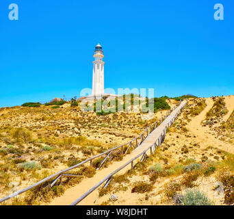 Holzsteg zum Faro de Trafalgar Leuchtturm, in Cabo de Trafalgar Kap Naturpark. Barbate, Conil de la Frontera, Cadiz. Andalusien, Spanien. Stockfoto