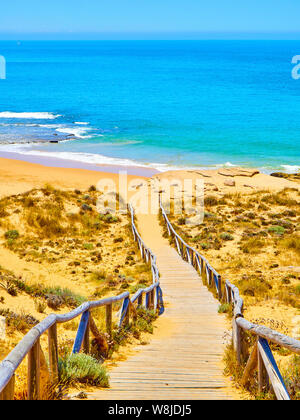 Holzsteg zum Faro de Trafalgar Strand, einem breiten Strand von Cabo de Trafalgar Kap natürlichen Park gehen. Barbate, Conil de la Frontera, Cadiz. Andalu Stockfoto