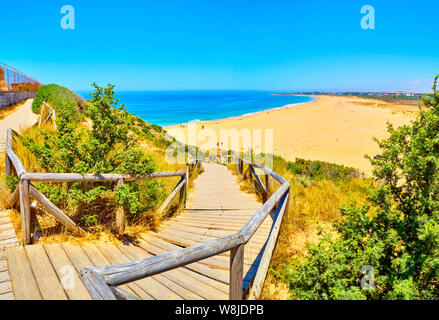 Holzsteg zum Faro de Trafalgar Strand, einem breiten Strand von Cabo de Trafalgar Kap natürlichen Park gehen. Barbate, Conil de la Frontera, Cadiz. Spanien. Stockfoto