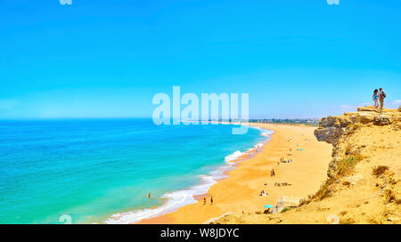 Touristen beobachten, das Faro de Trafalgar Strand, einem breiten Strand von Cabo de Trafalgar Kap Naturpark. Conil de la Frontera, Spanien. Stockfoto