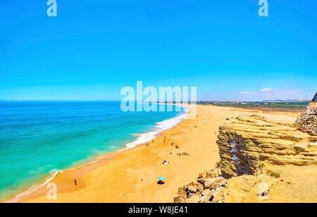 Die Menschen genießen Sie ein Sonnenbad in der Faro de Trafalgar Strand, einem breiten Strand von Cabo de Trafalgar Kap. Barbate, Spanien. Stockfoto