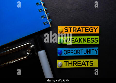 Strategie, Schwäche, Opporunity, Drohungen (SWOT) Text auf Haftnotizen auf Schwarzen Schreibtisch isoliert. Mechanismus Strategie Konzept Stockfoto
