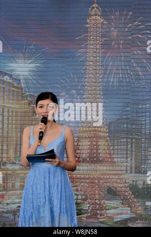 Eine Hostess spricht auf das Richtfest des halben große Nachbildung des Eiffelturms auf der Baustelle des Pariser Macau in Macau, Stockfoto