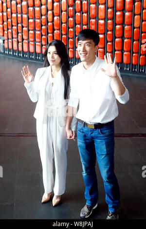 ---- Chinese star Hürdenspringer Liu Xiang, rechts, und seine Schauspielerin Frau Ge Tian Welle wie Sie ankommen am Ticket spende Zeremonie für St. Petersburg Phi Stockfoto
