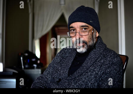 Porträt einer reifer Mann, ganz in schwarz gekleidet und mit Blick auf die Kamera. Stockfoto