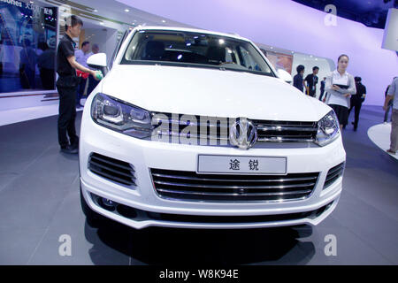 ---- Ein Arbeitnehmer Stäube aus einer importierten Touareg SUV von Volkswagen auf dem Display während der 12 China (Guangzhou) Internationale Automobil Ausstellung, Kno Stockfoto