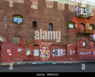 Verfallene rote Ziegelfassade der alten Industriegebäude im Arts District in Downtown Los Angeles. Graffiti und Street Art decken die Gebäude. Stockfoto