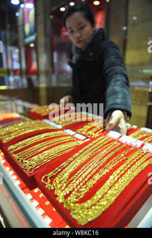 ---- Eine chinesische Angestellte zeigt Gold Halsketten an einem Juwelier in Lin'An, der ostchinesischen Provinz Zhejiang, 4. Februar 2016. China's Gold Reserv Stockfoto