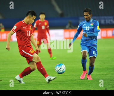 Hao Junmin von China, Links, Herausforderungen Amdhan Ali der Malediven in ihrer Gruppe C Match in der zweiten Runde der Asiatischen Qualifier für die 2018 FIFA Worl Stockfoto