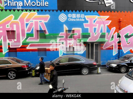 Fußgänger vorbei an einer Werbung für 4G-Dienste von China Mobile im Yunyang County, Chongqing, China, 23. März 2016. China Mobile ist der Große Stockfoto