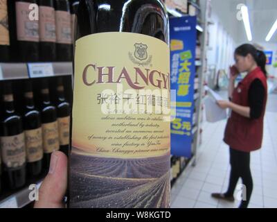 --FILE - ein chinesischer Kunde Geschäfte für eine Flasche Changyu classic trocken Rotwein in einem Supermarkt in Nantong City, der ostchinesischen Provinz Jiangsu, 1 Novem Stockfoto