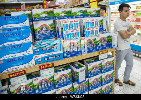 ------ Chinesische Kunden vorbei an Kartons von Milch von Hellen Molkerei in einem Supermarkt in Ningbo City, der ostchinesischen Provinz Zhejiang, 1. Oktober 2015. Stockfoto