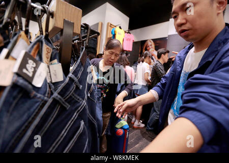 - - - - Kunden, von denen die meisten Chinesen sind, sind Einkaufsmöglichkeiten für Kleidung in einem Duty Free Shop in Bangkok, Thailand, 16. Februar 2016. Chinesischer Stockfoto