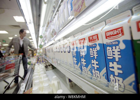 --FILE - ein chinesischer Kunde Geschäfte für Milch von Hellen Molkerei in einem Supermarkt in Shanghai, China, 2. April 2014. Helle Milchprodukte und Lebensmittel wurde verschrottet ein Pro Stockfoto