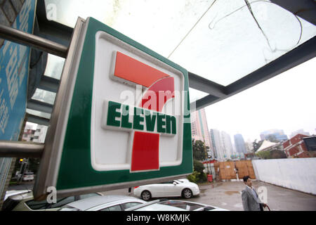 ---- Ein Fußgänger geht hinter einem Convenience Store von 7-Eleven in Shanghai, China, 30. März 2015. New Hope Group erwägt Ausweitung der 7-Ele Stockfoto