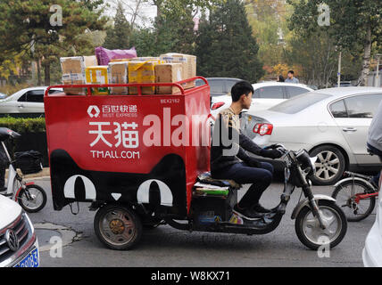 ---- Eine chinesische Kurier aus besten Express Fahrten ein elektrisches Dreirad auf einer Straße Pakete von Online-shopping bei Tmall.com von Alibaba Group zu liefern Stockfoto