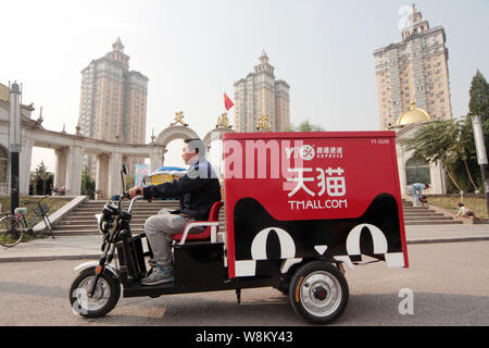 ---- Eine chinesische Kurier von YTO Express Fahrten ein elektrisches Dreirad auf einer Straße Pakete von Online-shopping bei Tmall.com von Alibaba Group zu liefern Stockfoto