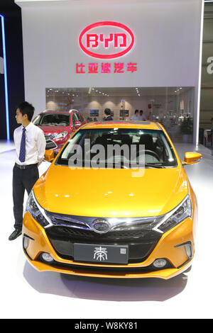 ---- Ein chinesischer Mitarbeiter steht neben einem BYD Qin Plug-in Hybrid Auto während des 13 China (Guangzhou) Internationale Automobil Ausstellung, auch Kno Stockfoto