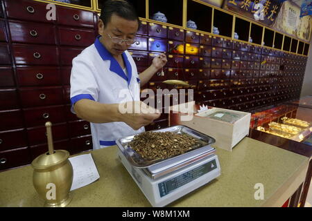 ---- Eine Chinesische pharmaceutist wiegt der Traditionellen Chinesischen Medizin bei einer TCM-Apotheke in der Stadt Yichang, Provinz Hubei im Zentrum von China, 19. September 20. Stockfoto